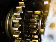Close-up of lubricated metal gears inside an industrial gearbox.