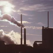 Power plant chimney stacks against the sky, illustrating how clean oil and advanced oil filtration improve turbine control stability and reduce valve sticking in power generation systems.