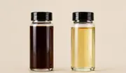 Technician comparing two oil samples with visibly different cleanliness levels.
