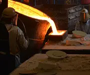 Molten metal being poured into a mould in a foundry, illustrating high-quality metal casting production.