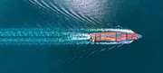 Aerial view of a container ship sailing across open water, representing global business operations and data responsibility.