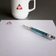 C.C.JENSEN branded notepad and pen on a desk, representing learning, knowledge sharing, and employee development.