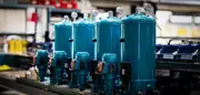 Row of blue CJC oil filtration units in a workshop, representing global service support and equipment protection.