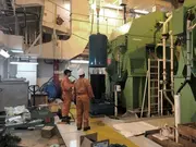 Engineers working beside a large marine thruster system in a ship engine room during lubrication oil dehydration service.
