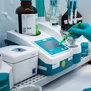 Laboratory technician using analytical testing equipment to support quality control and ISO 9001 quality management.