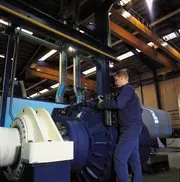 Technician servicing wind turbine drivetrain equipment inside a nacelle, illustrating how clean oil and effective oil filtration improve pitch system response and reduce oil-related interventions.