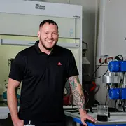 Employee portrait of a marine application engineer standing in an industrial work environment.
