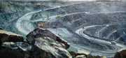 Open-pit mine with heavy equipment operating on terraced excavation roads, representing mineral sourcing and traceability.