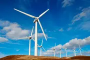 Wind turbines against a blue sky, illustrating how clean oil and advanced oil filtration protect gearboxes and hydraulic systems to ensure reliable wind turbine performance and stable uptime.