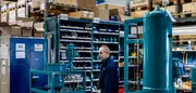 Technician working in a CJC spare parts warehouse with filtration components and shelving in the background.