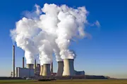 Power plant with cooling towers and steam plumes, where clean oil and high-performance oil filtration protect turbines and auxiliary systems to ensure reliable power generation.