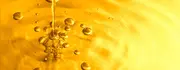 Close-up of golden oil with bubbles and droplets, illustrating clean, flowing lubricant.