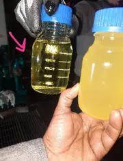 Two oil samples in bottles comparing clean turbine oil and water-contaminated oil.