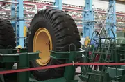Large tyre curing press machinery inside an industrial tyre manufacturing plant.
